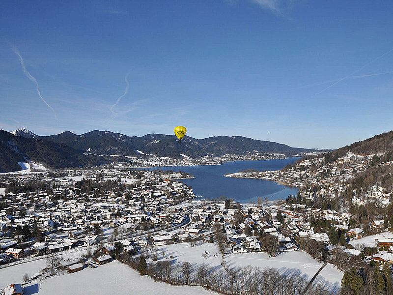 Verschneite Stadt in den Alpen mit großem See