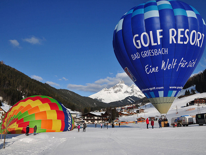 Blauer Ballon mit großem Werbedruck auf einer Skipiste